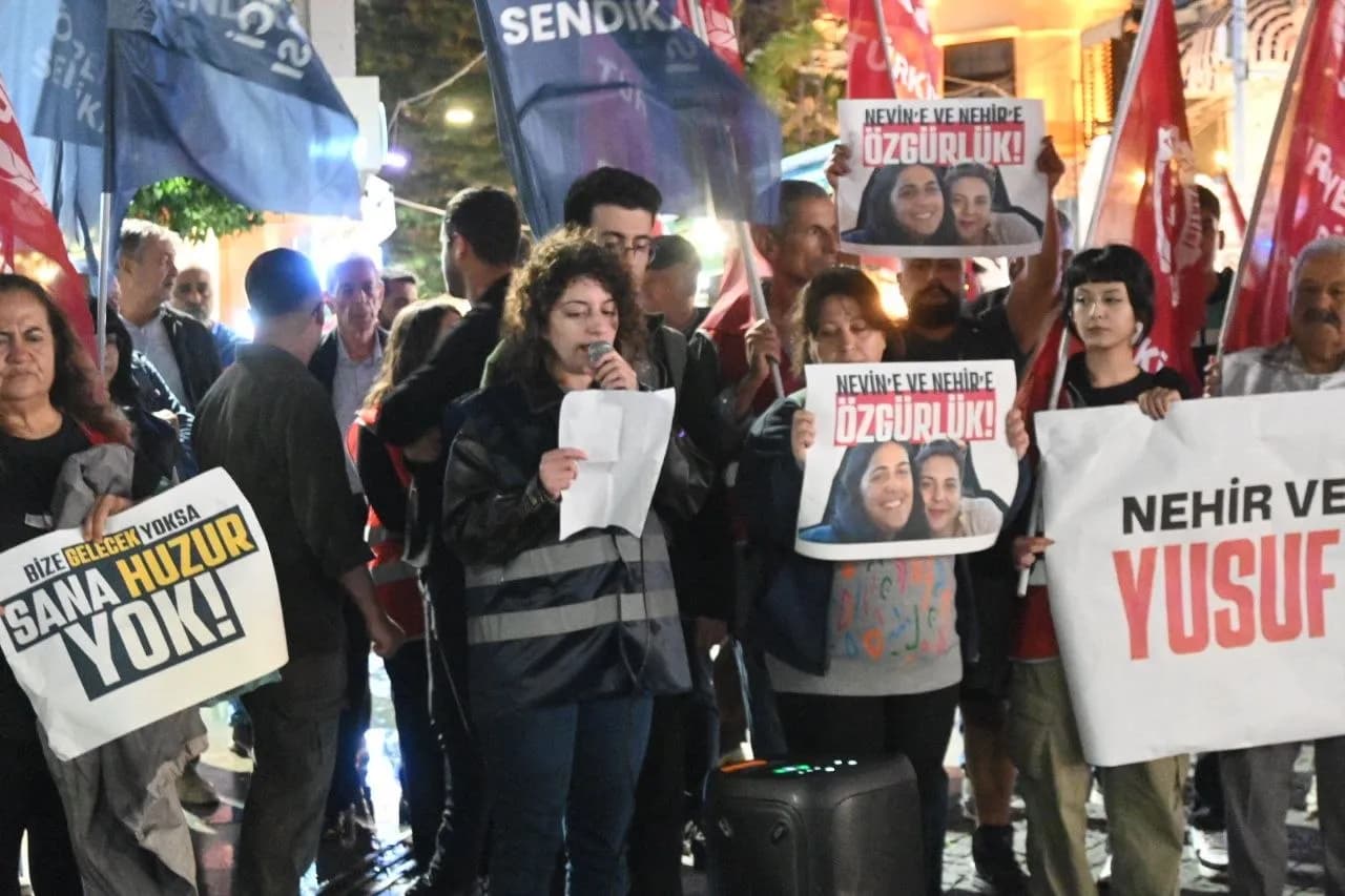 eylem görüntüsü kadın öğrenci elinde mikrofon konuşuyor yanında diğer öğrenciler karanlık