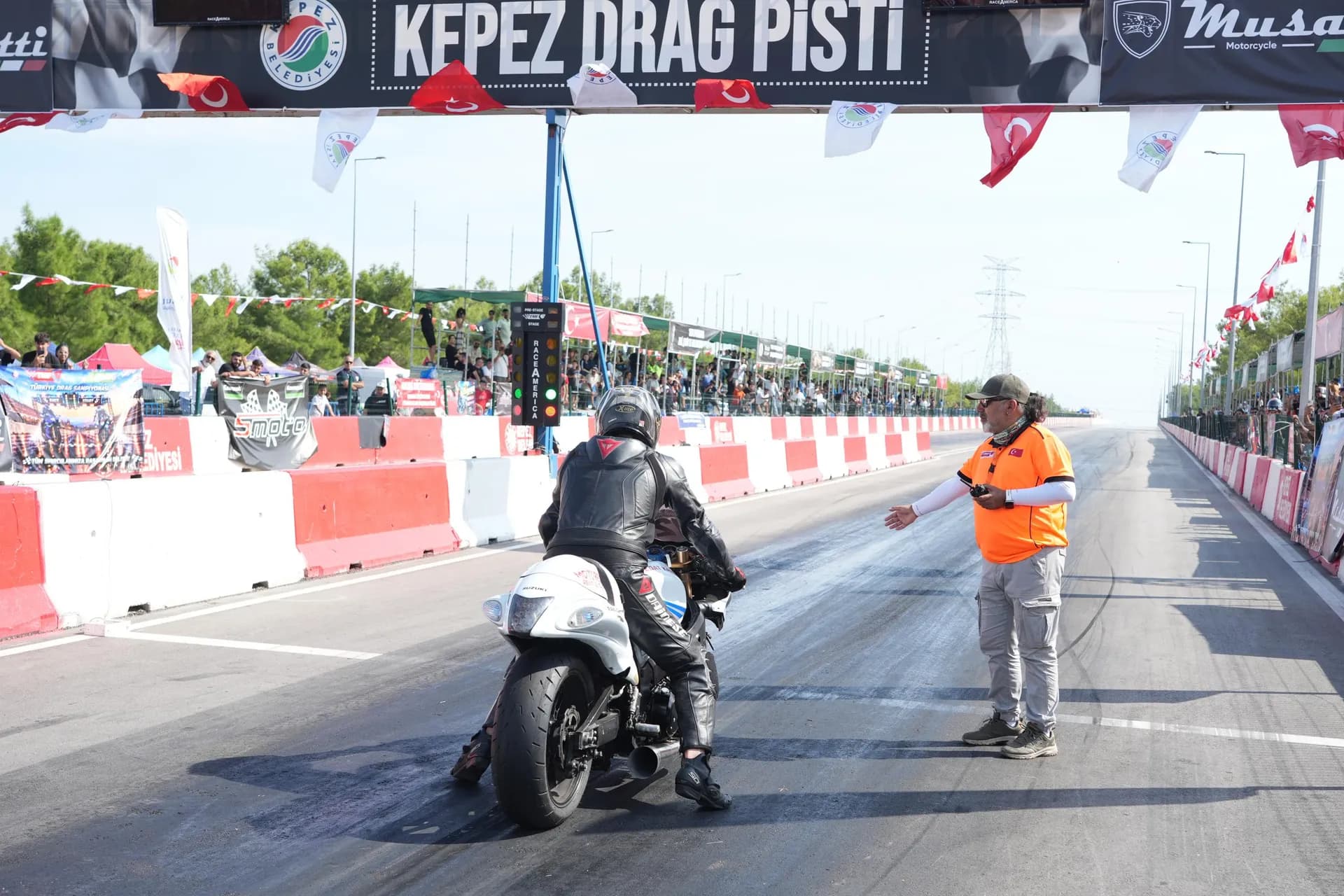 Motor sürücüsü motorun üstünde drag pistinde startı bekliyor