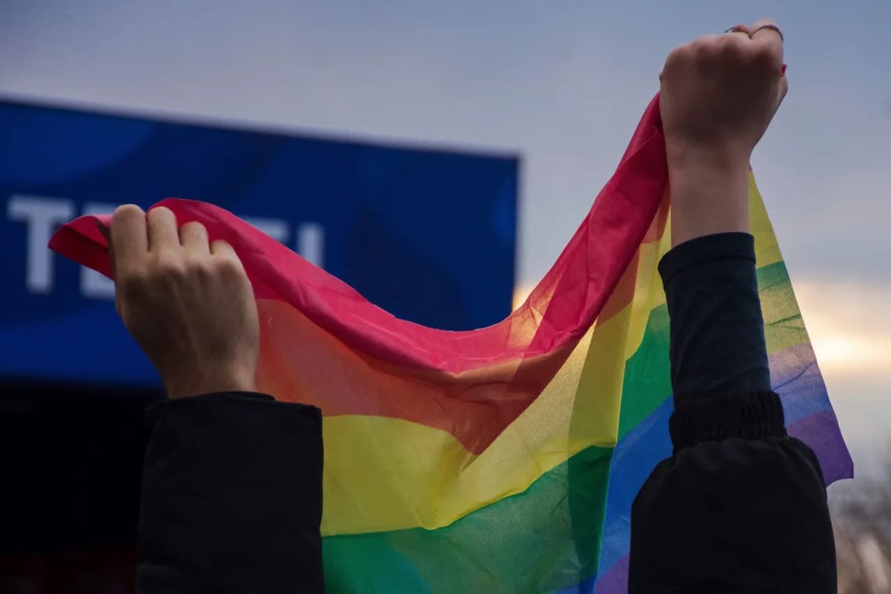 LGBTİ bayrağı iki el iki ucundan tutuyor